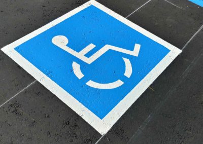A blue and white handicap sign on a parking lot.
