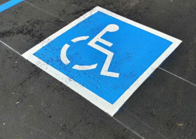 A disabled parking sign with a person in a wheelchair.