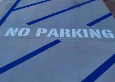 A no parking sign painted on a sidewalk.