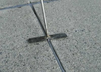 A metal rod sticking out of a concrete slab.