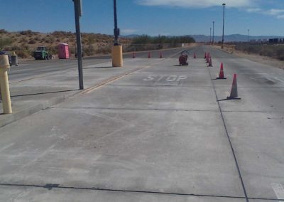 A road with traffic cones and a stop sign.