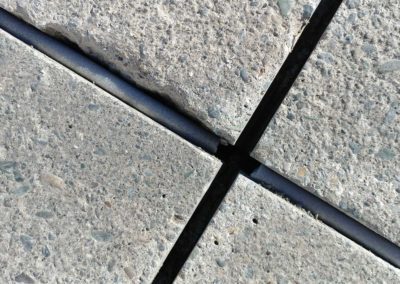 A close up of a concrete sidewalk with a metal rod.