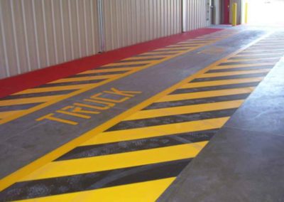 A yellow and black striped floor in a warehouse.
