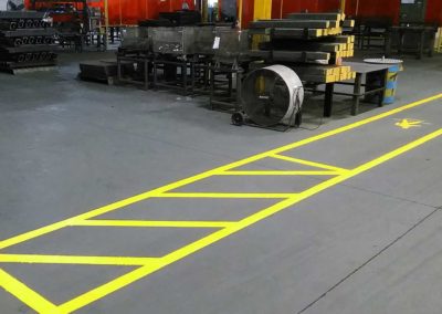 A yellow line on the floor of a factory.
