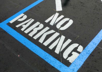 A no parking sign is painted on a parking lot.
