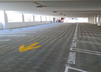 A parking lot with a yellow arrow pointing to a parking space.