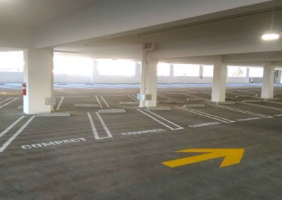 A parking lot with yellow arrows pointing in different directions.