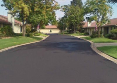 A black paved road in a residential area.