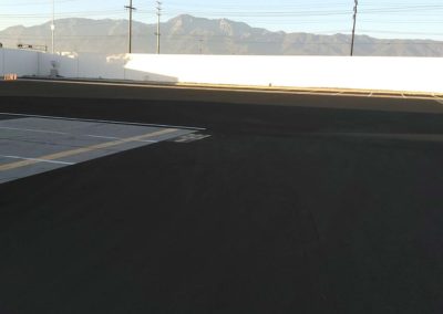 A black parking lot with mountains in the background.